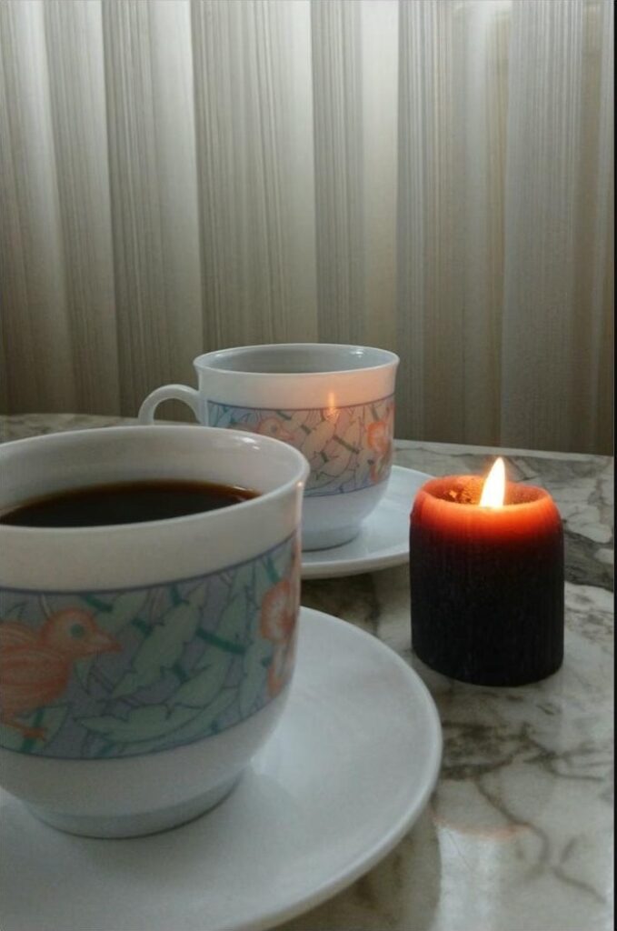 Deux tasses de café face à face à la lueur d'une bougie, ambiance propice à une conversation intime
