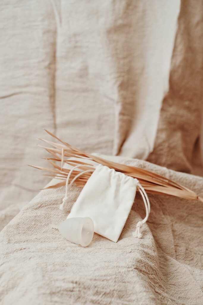 Pochette en coton et brins secs sur lin beige, ambiance douce coupe et culotte menstruelle