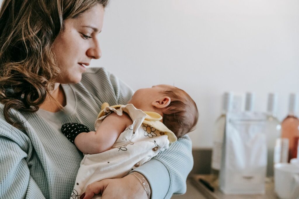 Mère tenant son bébé tendrement dans ses bras, lien maternel et douceur