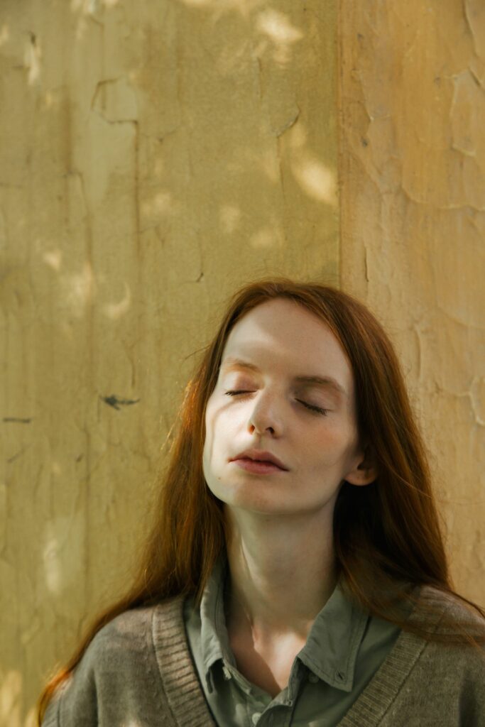 Portrait de femme rousse les yeux fermés, expression rêveuse et sereine - fantasmes féminins