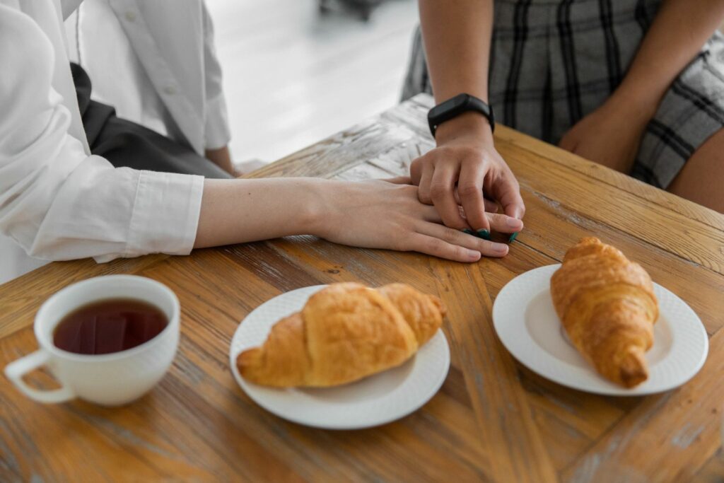 Mains d'un couple se rejoignant au-dessus d'une table de petit-déjeuner, moment de complicité retrouvée